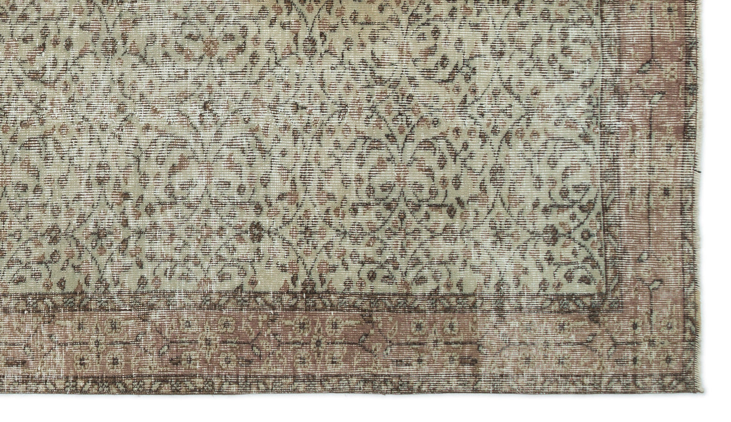 Beige and muted rose vintage-style rug with a distressed floral vine pattern and a wide decorative border.