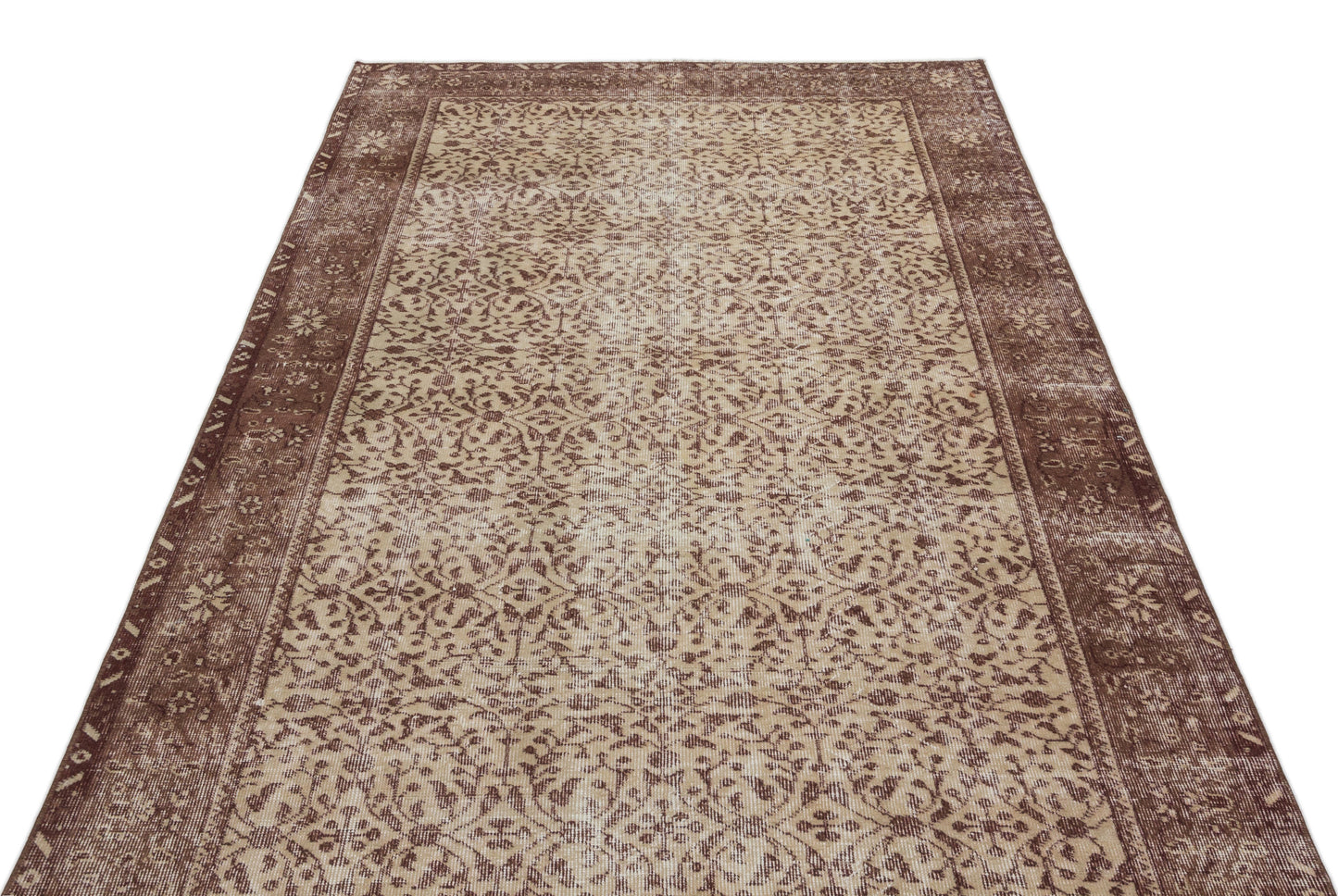 Brown and beige vintage-style rug with a distressed floral medallion pattern and a wide decorative border.