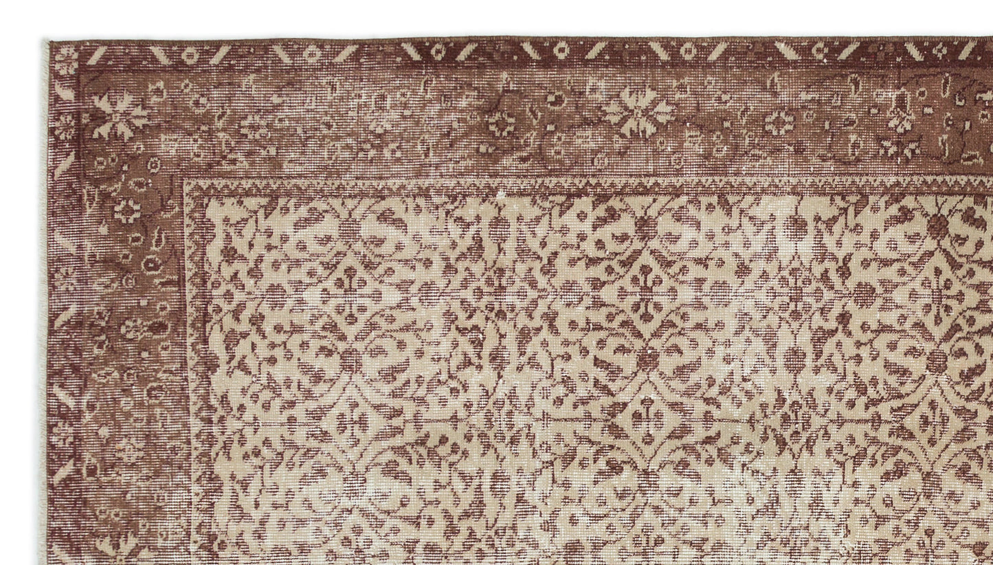 Brown and beige rug with a distressed traditional floral medallion pattern and a wide decorative border.