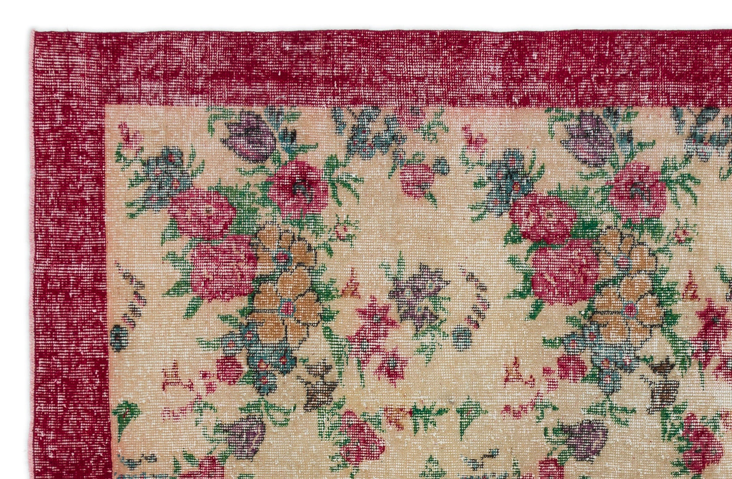 Distressed beige rug with a deep red border and a multi-colored floral pattern in pink, green, and purple.