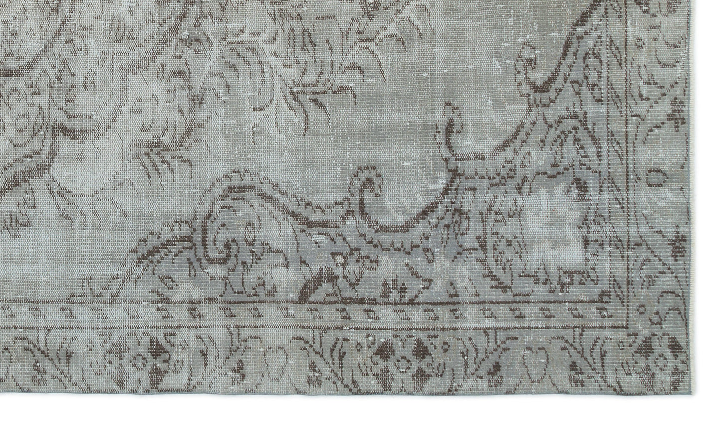 Grey and brown distressed rug with a traditional ornate floral medallion pattern and a bordered edge.