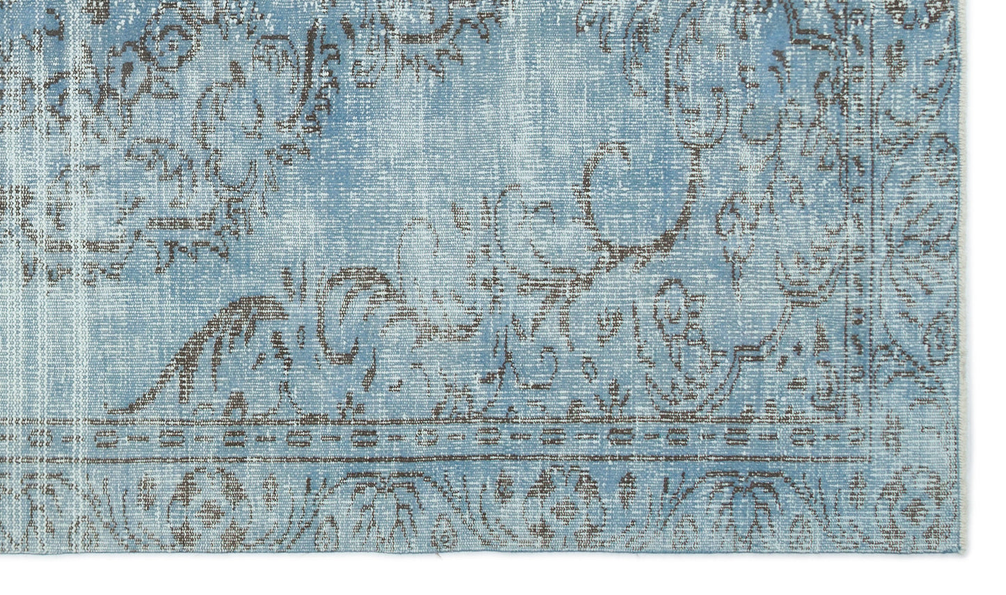 Light blue and grey distressed rug with a faded traditional floral medallion pattern.