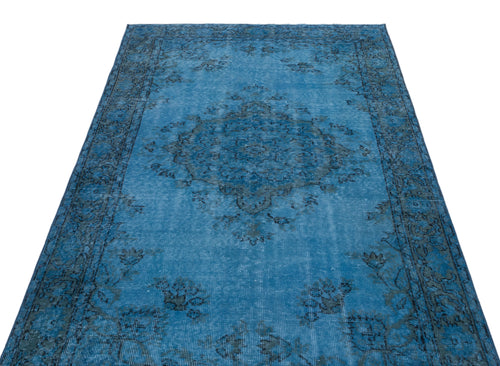 Load image 1 in gallery view. Bright blue distressed rug with a dark grey traditional floral medallion and border pattern on a white background.