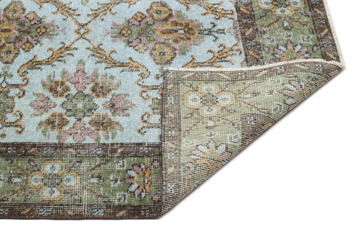 Load image 1 in gallery view. Light blue and green traditional rug with a floral medallion pattern and a folded corner showing the underside.