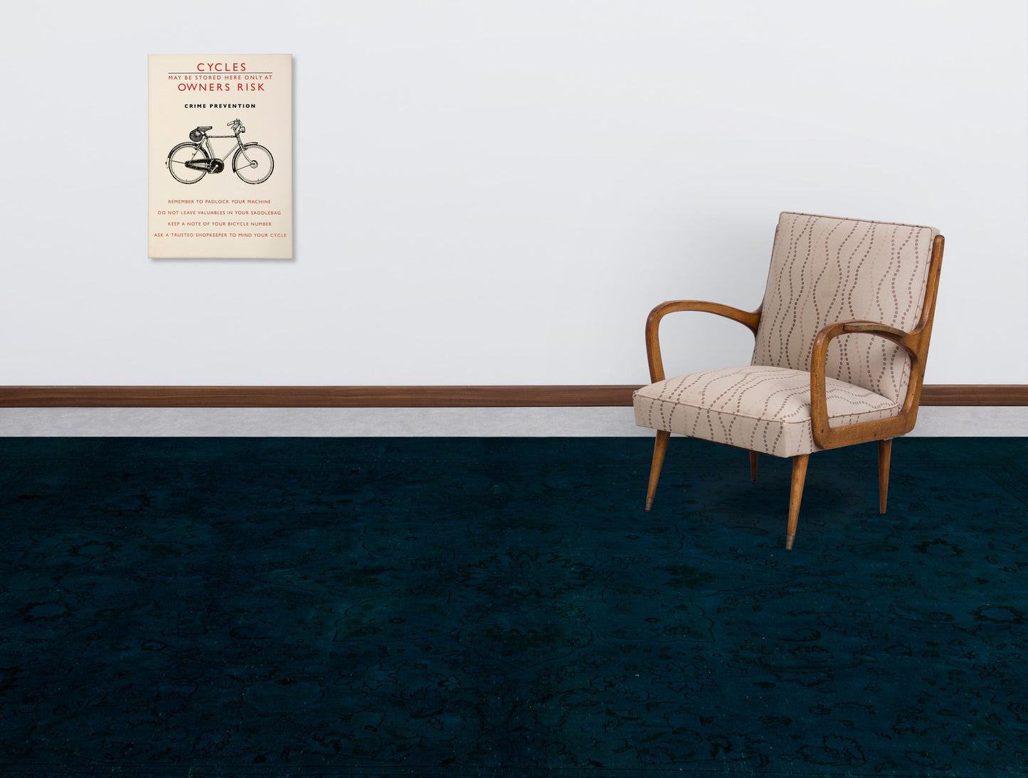 Dark teal rug with a subtle tonal floral pattern, styled in a room with a mid-century armchair and wall art.