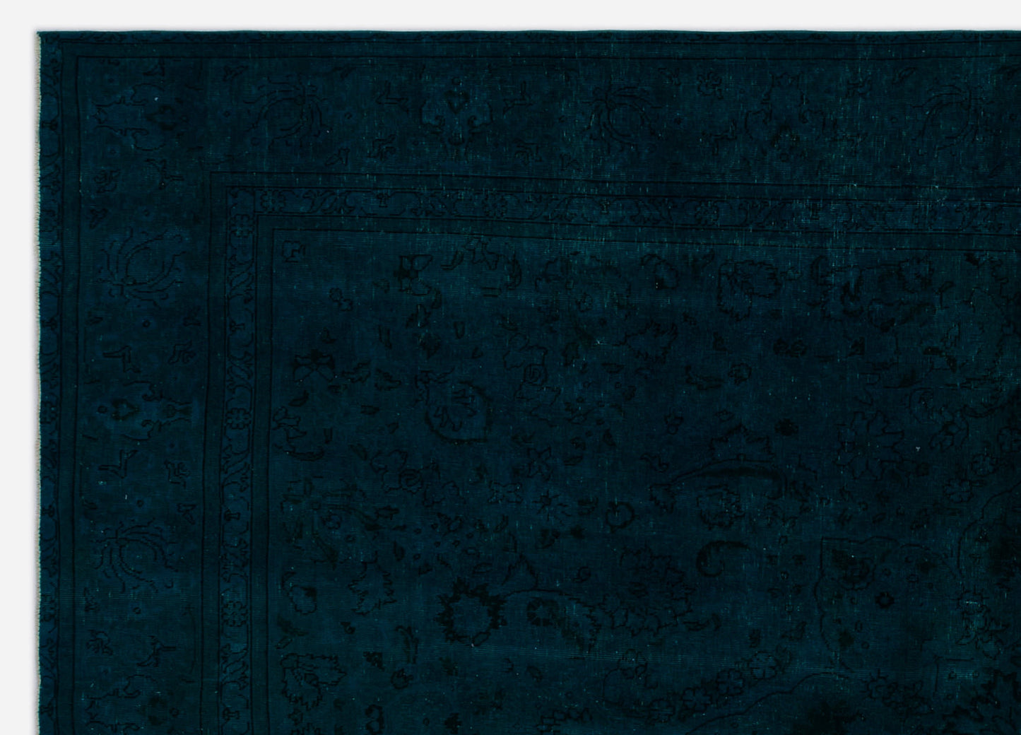 Dark teal rug with a subtle, tonal floral pattern and a thin linear border.
