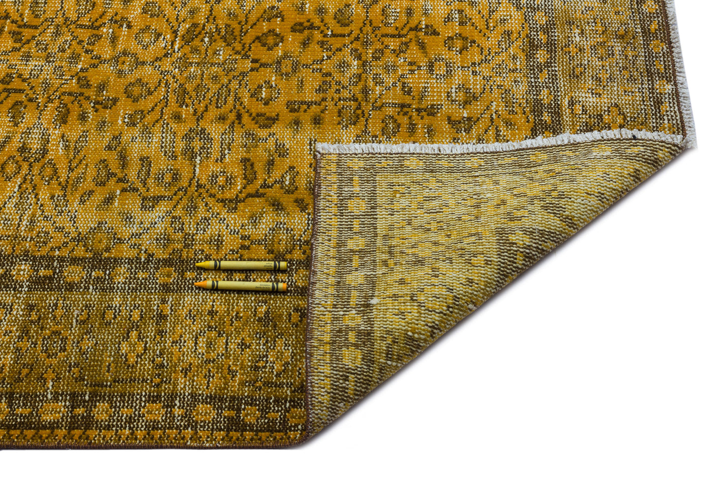 Mustard yellow and brown traditional rug with a floral medallion pattern, shown with a corner folded over.