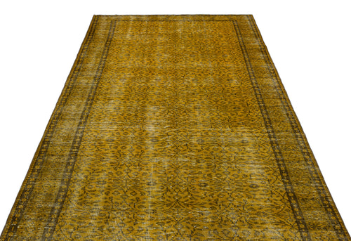 Load image 1 in gallery view. Mustard yellow vintage-style rug with a distressed floral pattern and dark border on a white background.