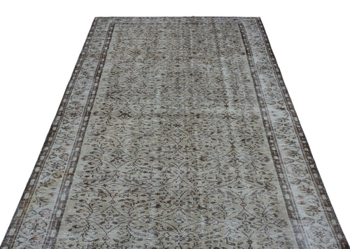 Load image 1 in gallery view. Beige and brown vintage-style rug with a distressed floral medallion pattern and a decorative border.