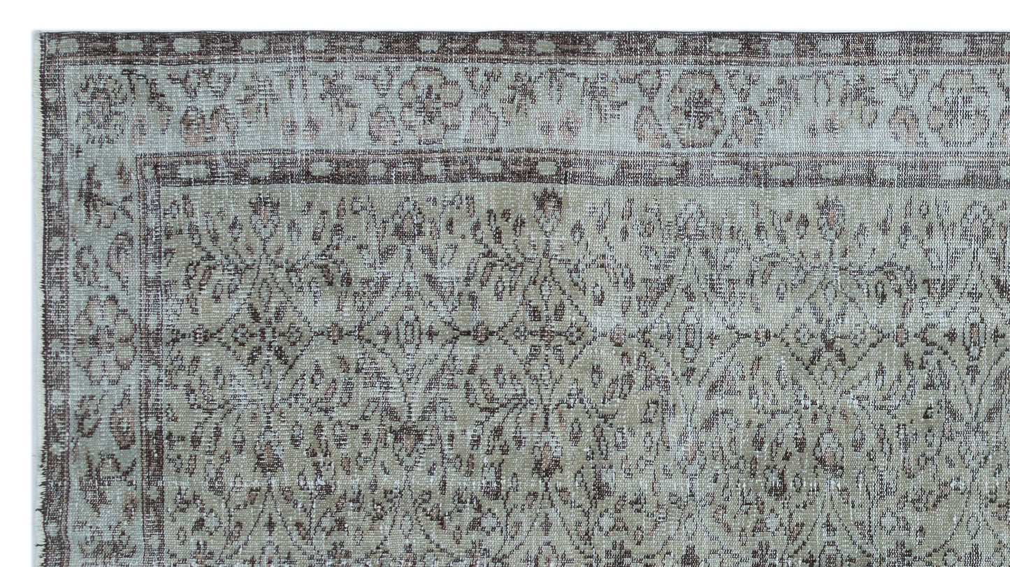 Distressed taupe and grey rug with a traditional floral medallion pattern and a geometric border.
