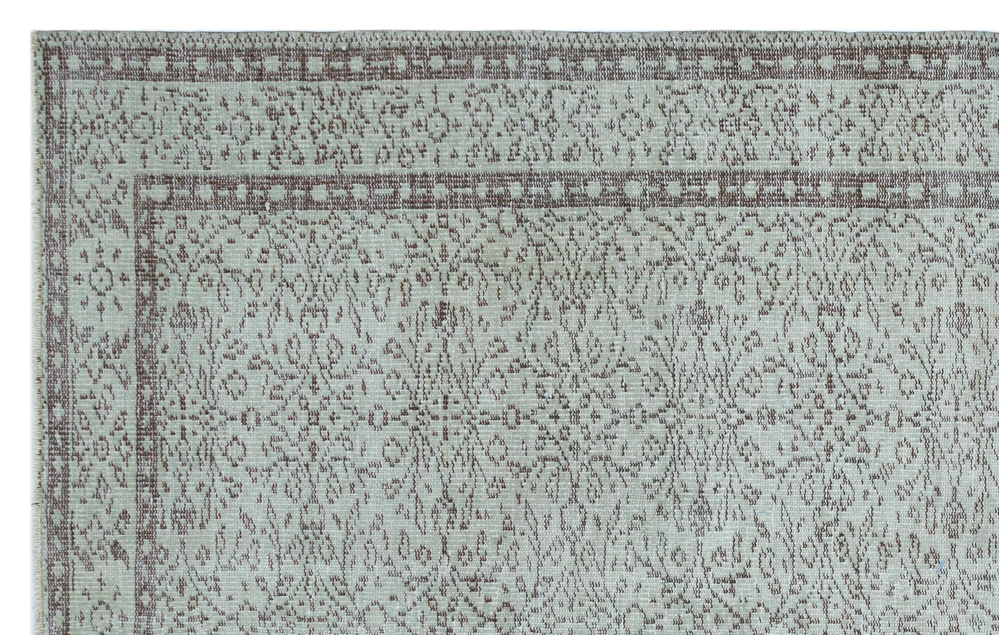 Light gray and taupe rug with a distressed traditional floral medallion pattern and a geometric border.