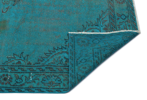 Load image 1 in gallery view. Teal vintage-style rug with a dark grey floral border and a folded corner showing the underside weave.