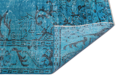 Load image 1 in gallery view. Distressed turquoise and black traditional patterned rug with a folded corner, isolated on a white background.