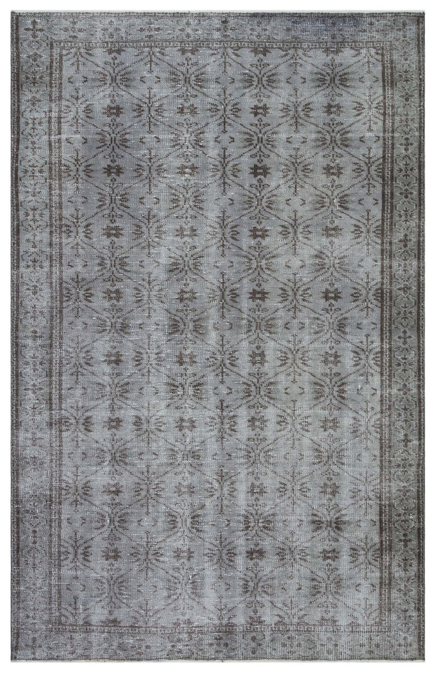 Grey and charcoal distressed rug with a repeating geometric lattice and floral motif, featuring a decorative border.