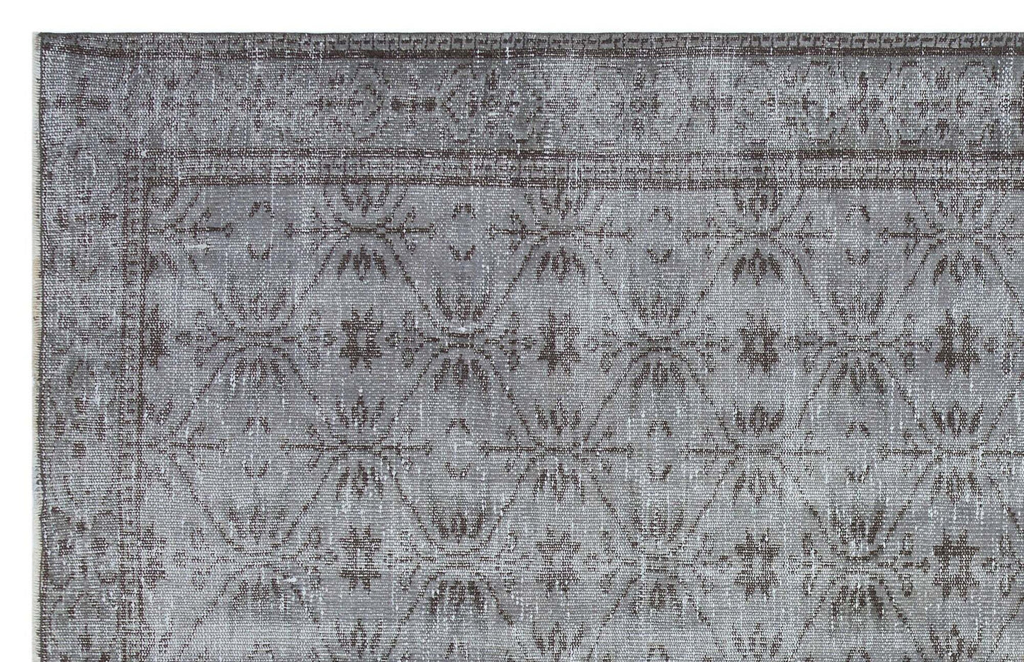 Grey and charcoal distressed rug with a repeating geometric diamond and floral medallion pattern.