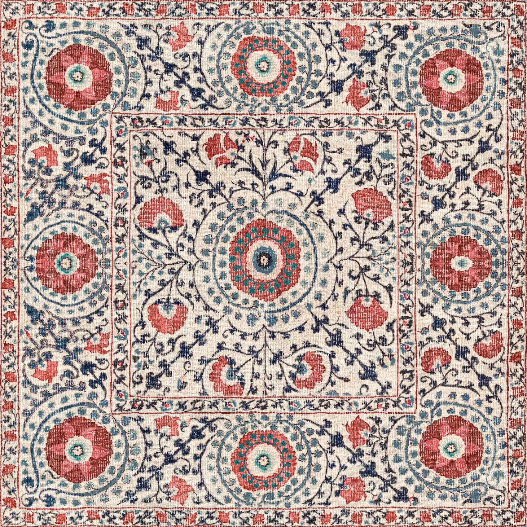 Decorative rug with intricate floral and geometric pattern in red, blue, and beige.