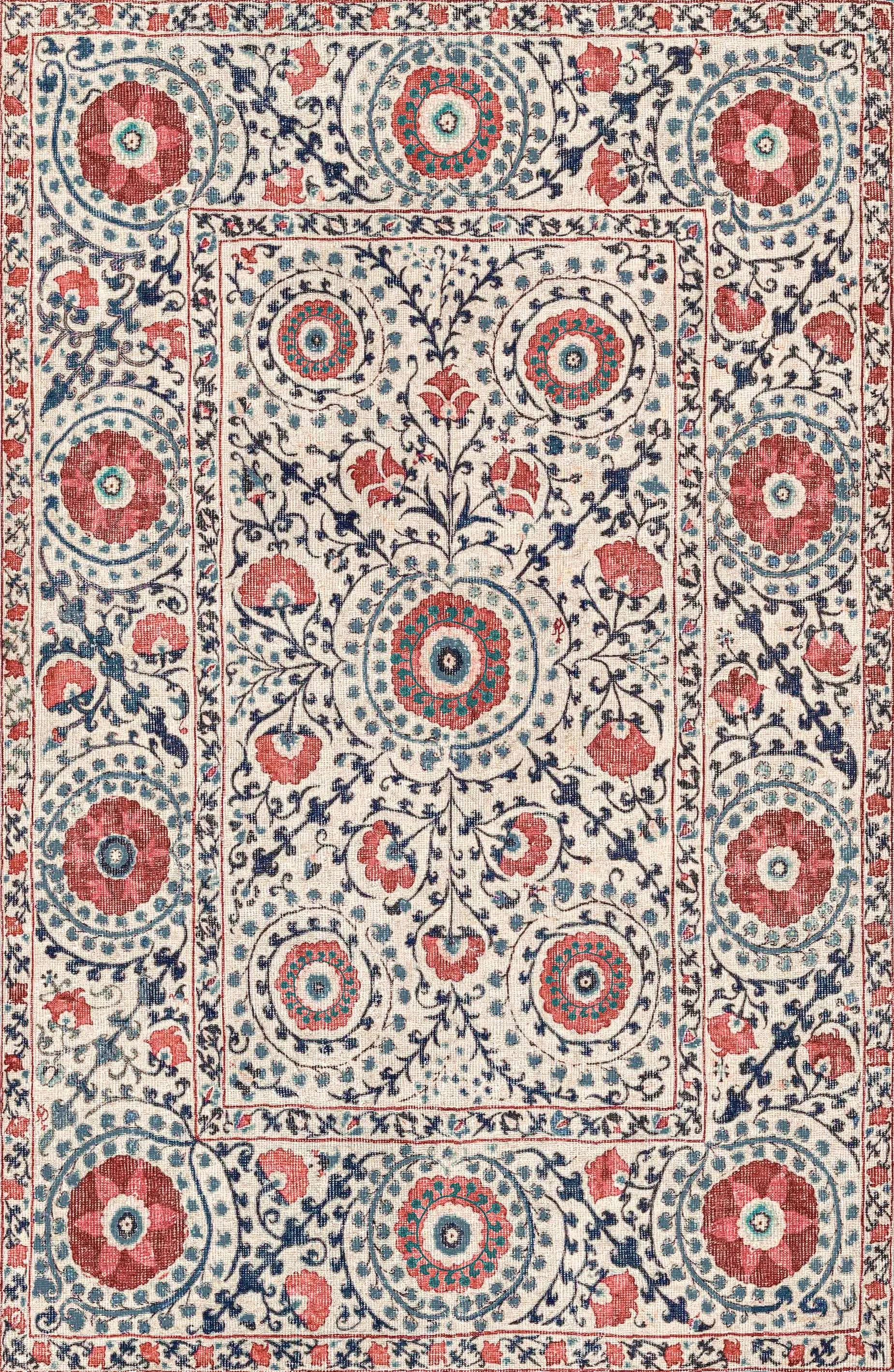 Decorative rug with floral and geometric pattern in red, blue, and beige.