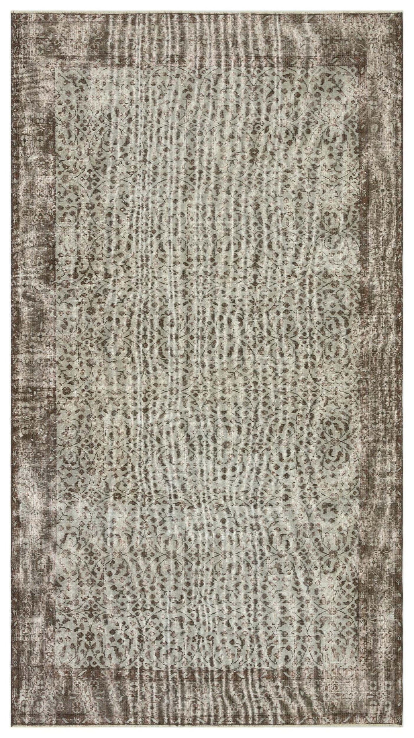 Taupe and cream distressed rug with a traditional repeating floral medallion pattern and a wide border.