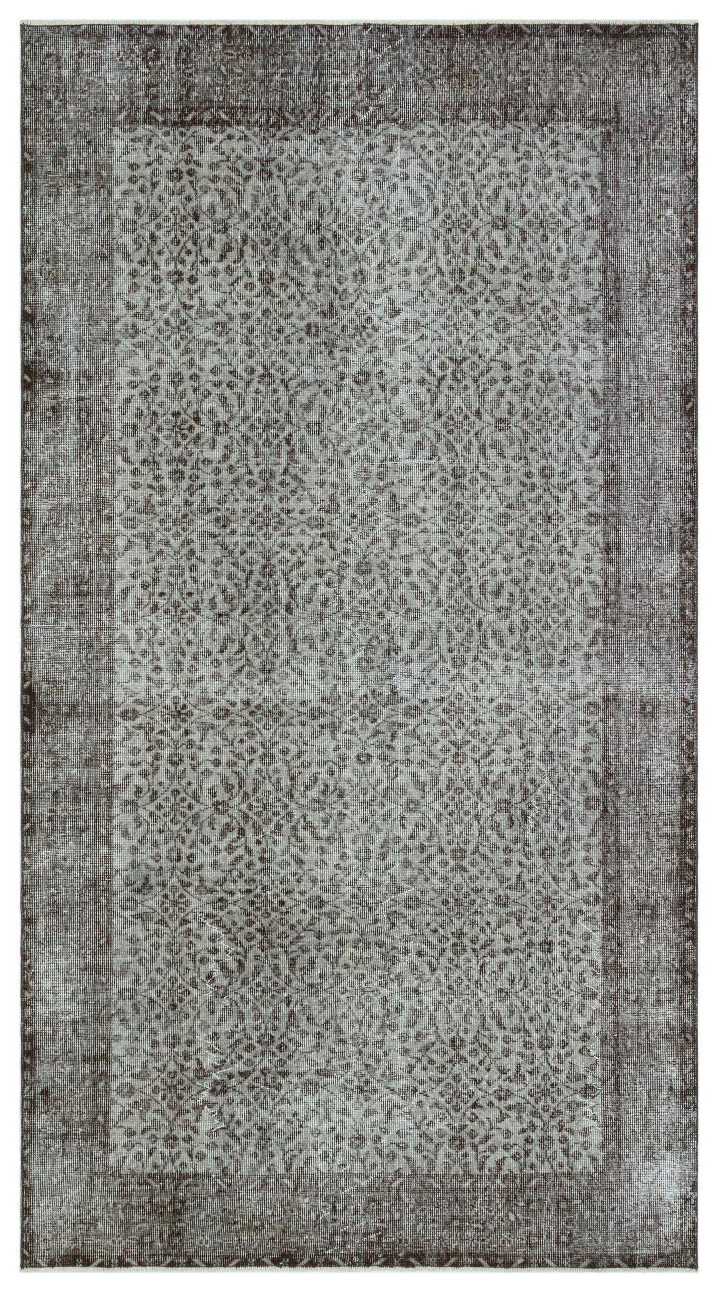 Charcoal and grey distressed rug with an intricate, repeating floral medallion pattern and a wide border.