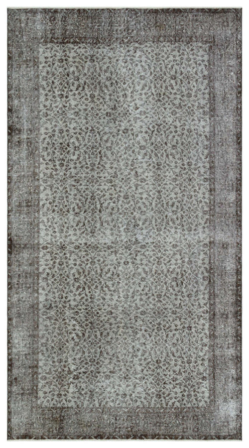 Load image 1 in gallery view. Charcoal and grey distressed rug with an intricate, repeating floral medallion pattern and a wide border.