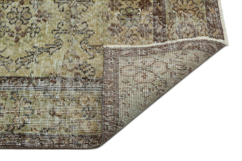 Bild 1 in Galerieansicht laden. Distressed beige and brown rug with a traditional floral medallion pattern, shown with a corner folded over.