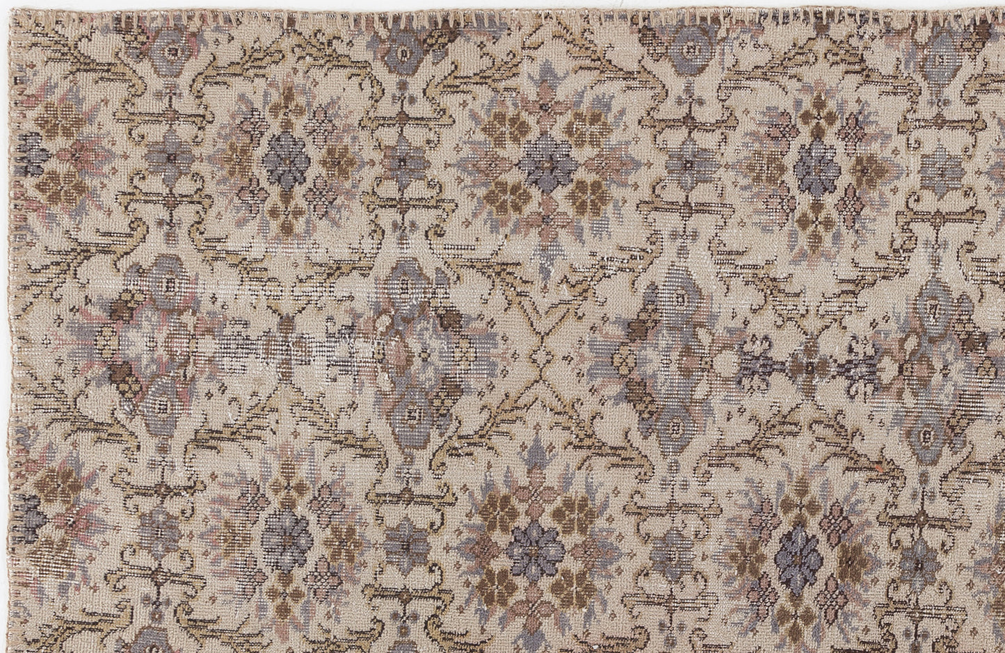 Beige rug with a distressed, repeating floral medallion pattern in muted tones of slate blue, brown, and soft pink.