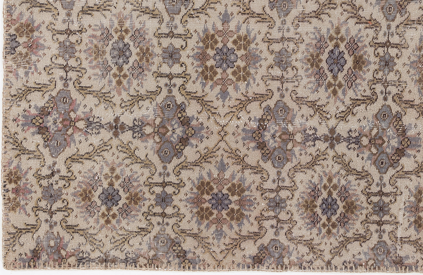 Beige rug with a repeating floral medallion pattern in muted tones of slate blue, brown, and dusty rose.