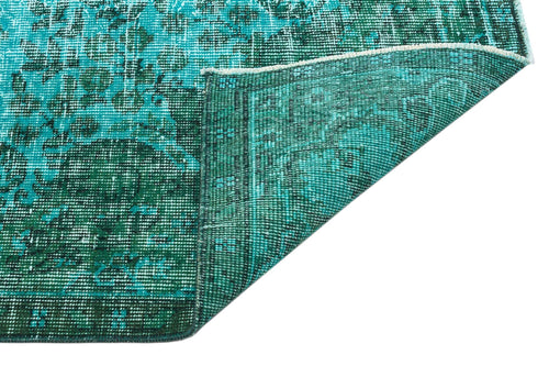 Load image 1 in gallery view. Teal and dark green distressed rug with a traditional medallion pattern, shown with a corner folded over.