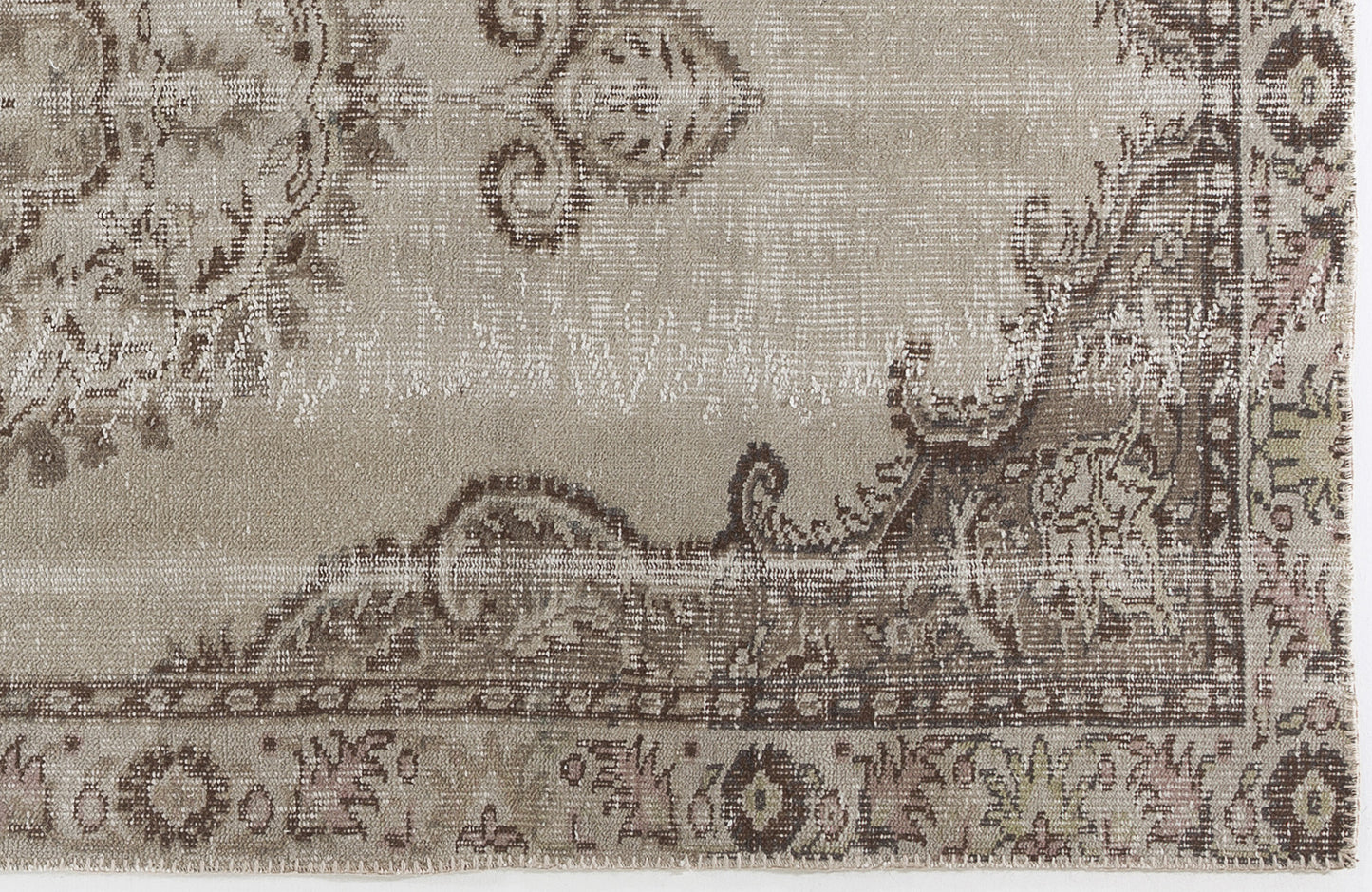 Taupe and brown distressed rug with a faded traditional floral medallion pattern.