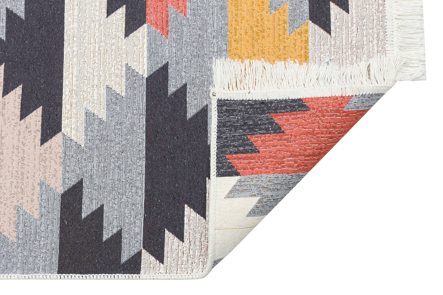 The Artisan Touch - Washable Double-Sided Kilims - AR20 features a reversible design with geometric zigzag patterns in gray, black, peach, yellow, and red, partially folded to reveal the underside and its white fringe.