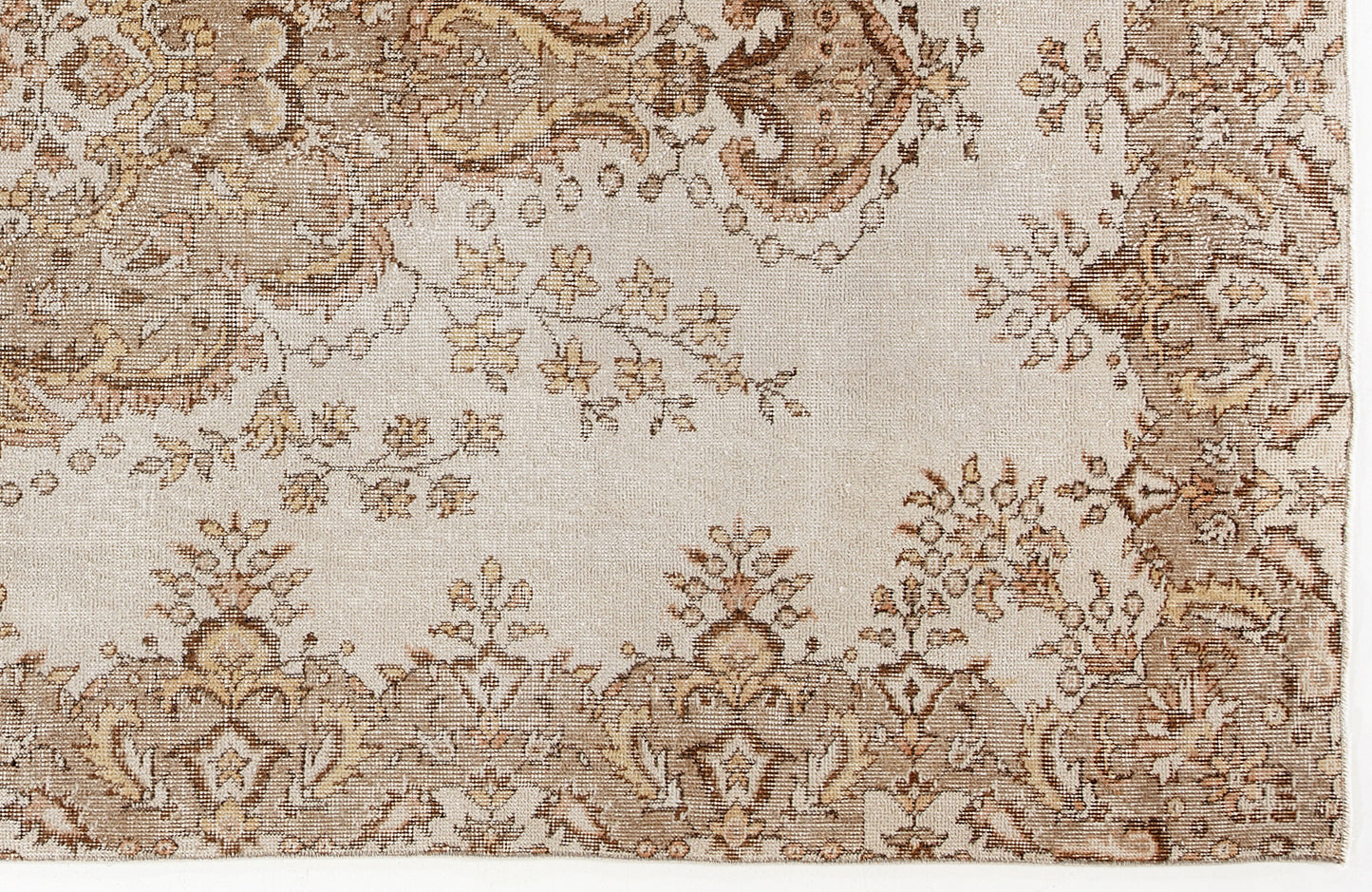 Beige and brown rug with a traditional floral medallion pattern and distressed texture.