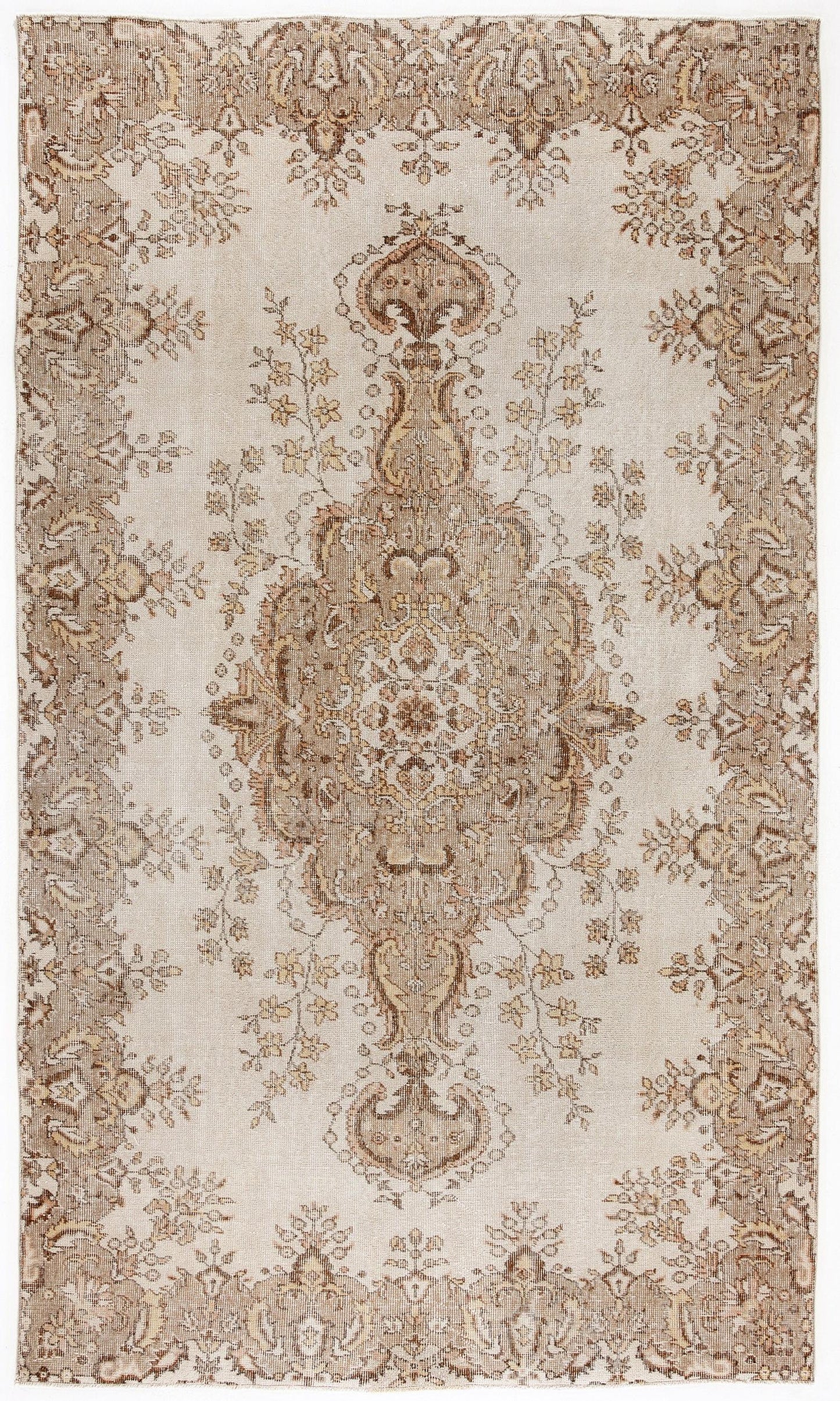 Beige and brown distressed rug with a central floral medallion and ornate border pattern.