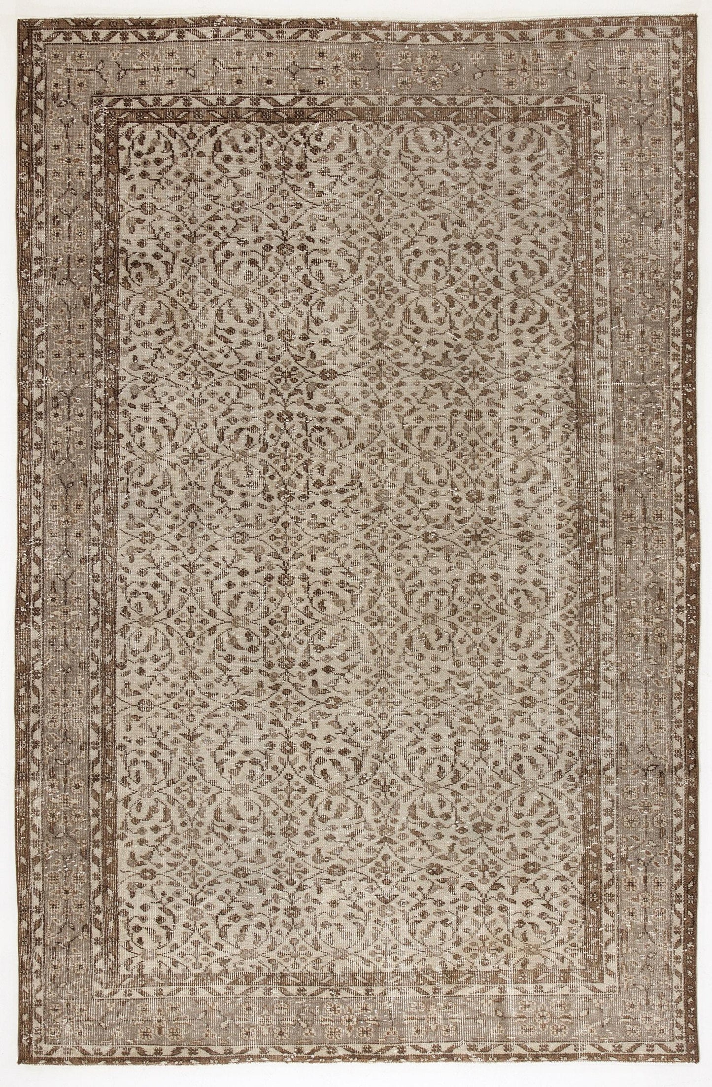 Taupe and brown distressed vintage-style rug with a repeating floral medallion pattern and a wide decorative border.