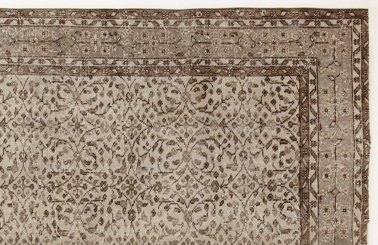 Taupe and brown vintage-style rug with a distressed floral vine pattern and a geometric border.