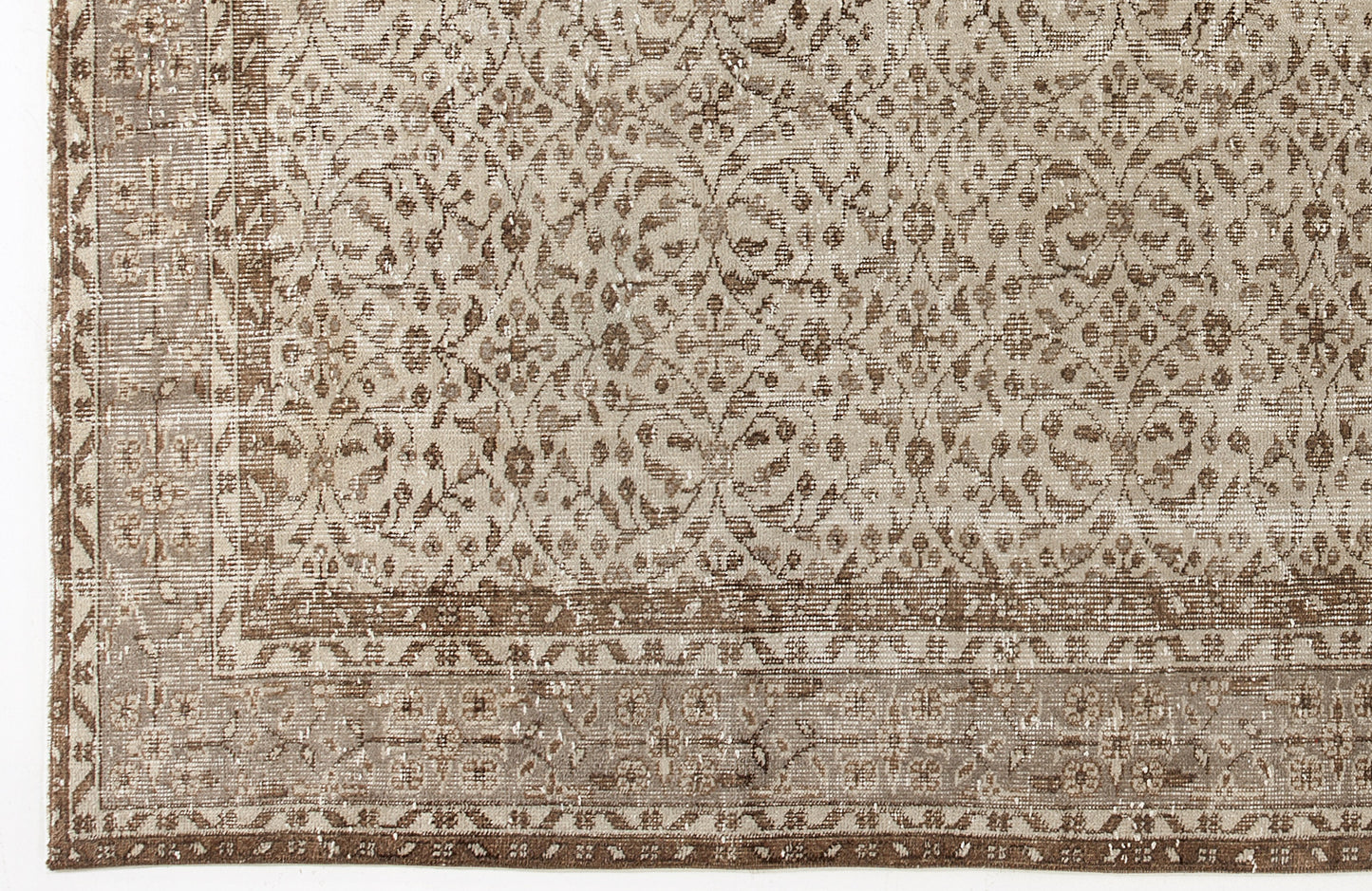 Beige and brown distressed rug with a traditional floral medallion pattern and a detailed border.