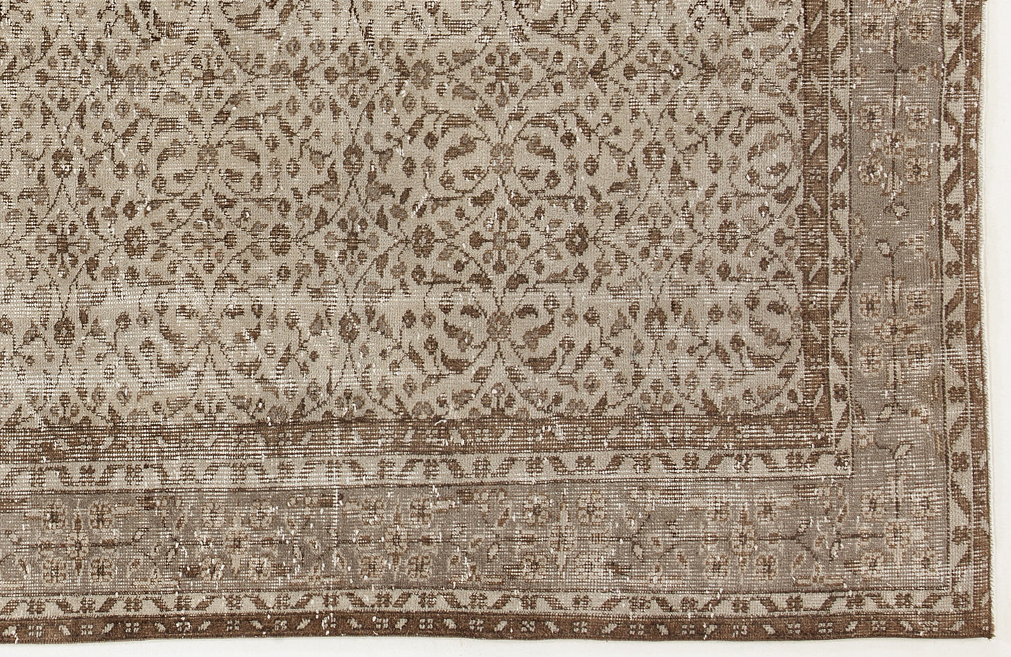 Taupe and brown distressed rug with a traditional floral medallion pattern and a decorative border.