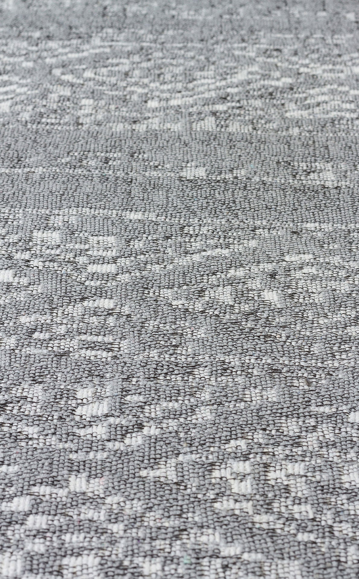Close-up of Modern Mist - Washable Double-Sided Kilims - AR01: a textured gray woven fabric with a subtle geometric pattern, featuring varied surfaces of small raised and flat areas for a modern look.