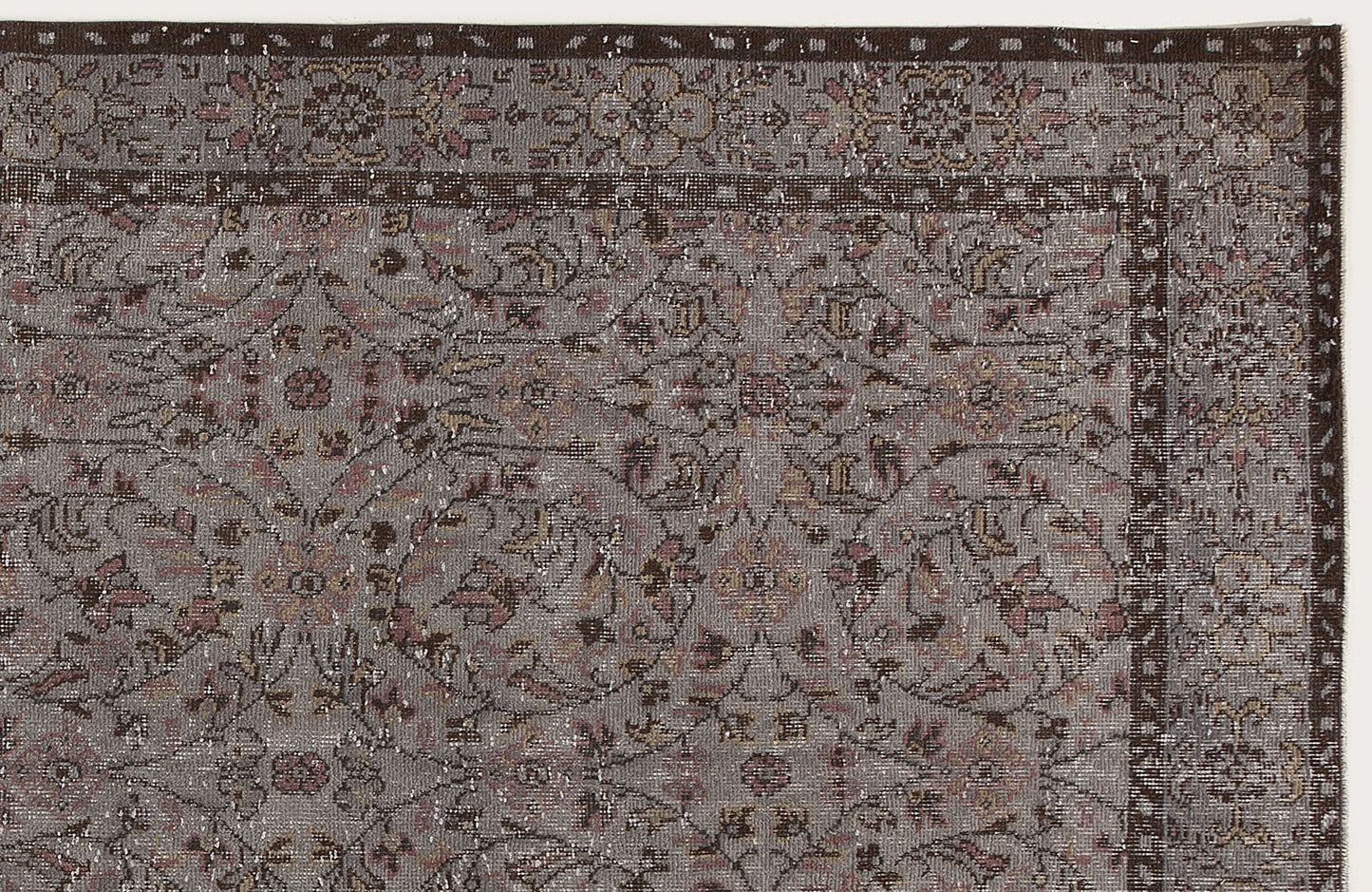 Grey and brown traditional rug with a distressed floral medallion pattern and a dark border.