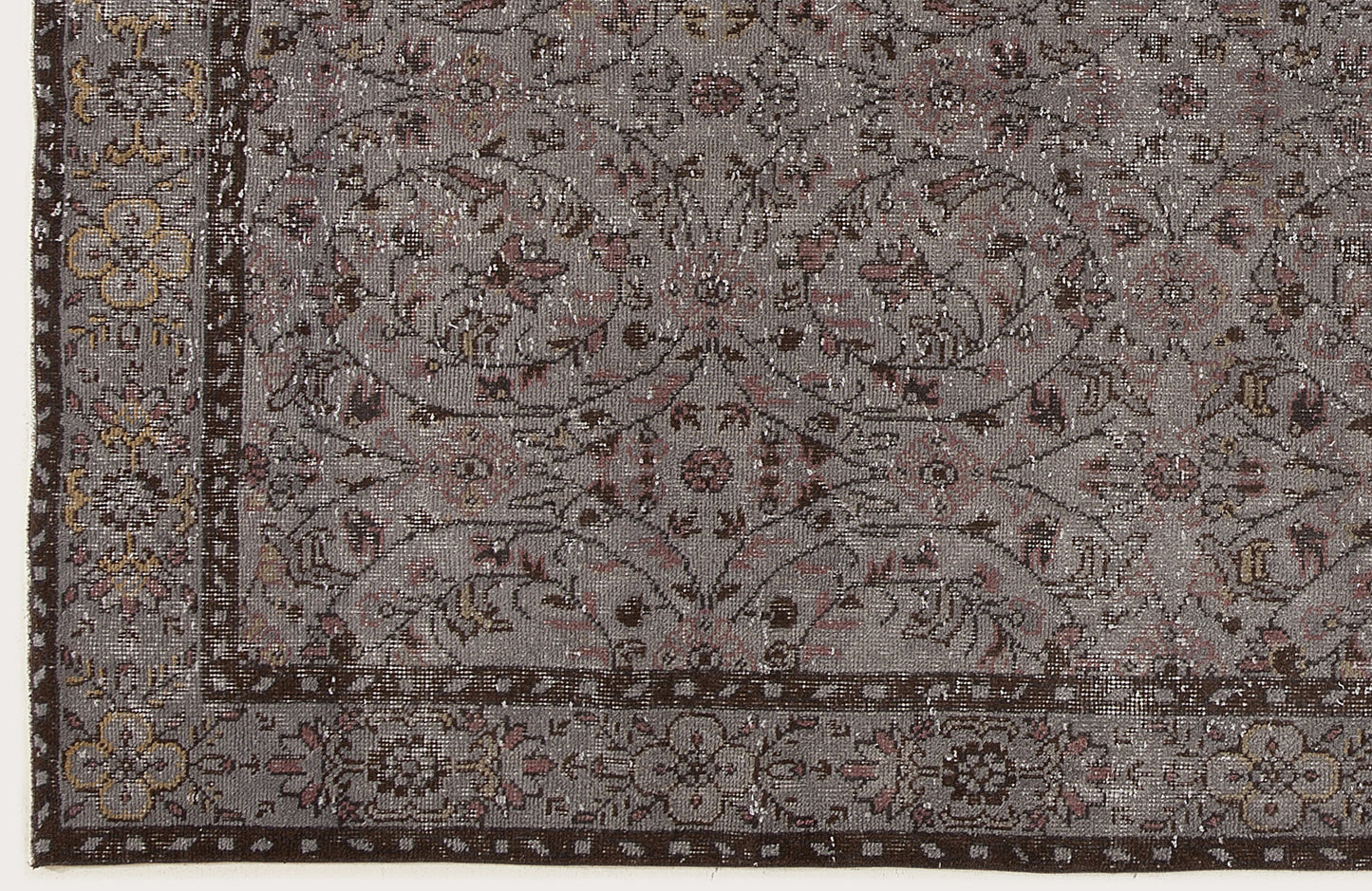 Grey and brown vintage-style rug with a distressed floral medallion pattern and a detailed border.
