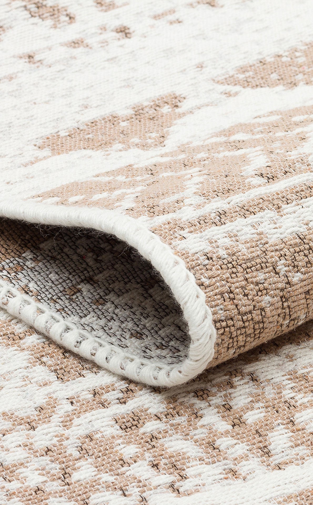 A close-up of the Earth Lines - Washable Double-Sided Kilims - AR06, showing its folded edge, beige and white abstract pattern, and textured, tightly stitched surface.