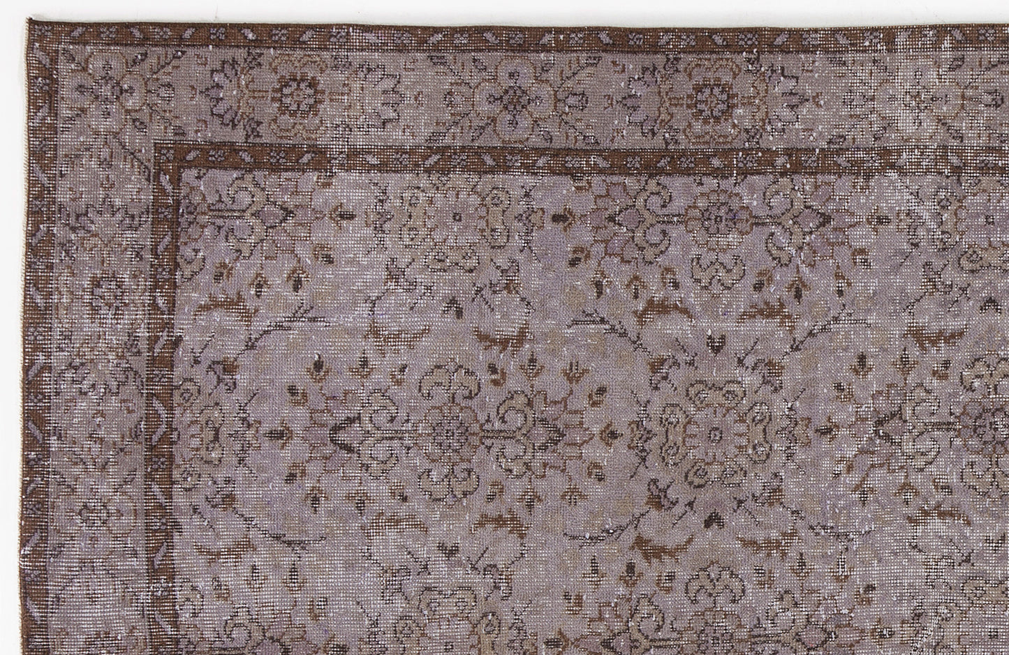 Distressed lavender and brown rug with a traditional floral medallion pattern and a decorative border.