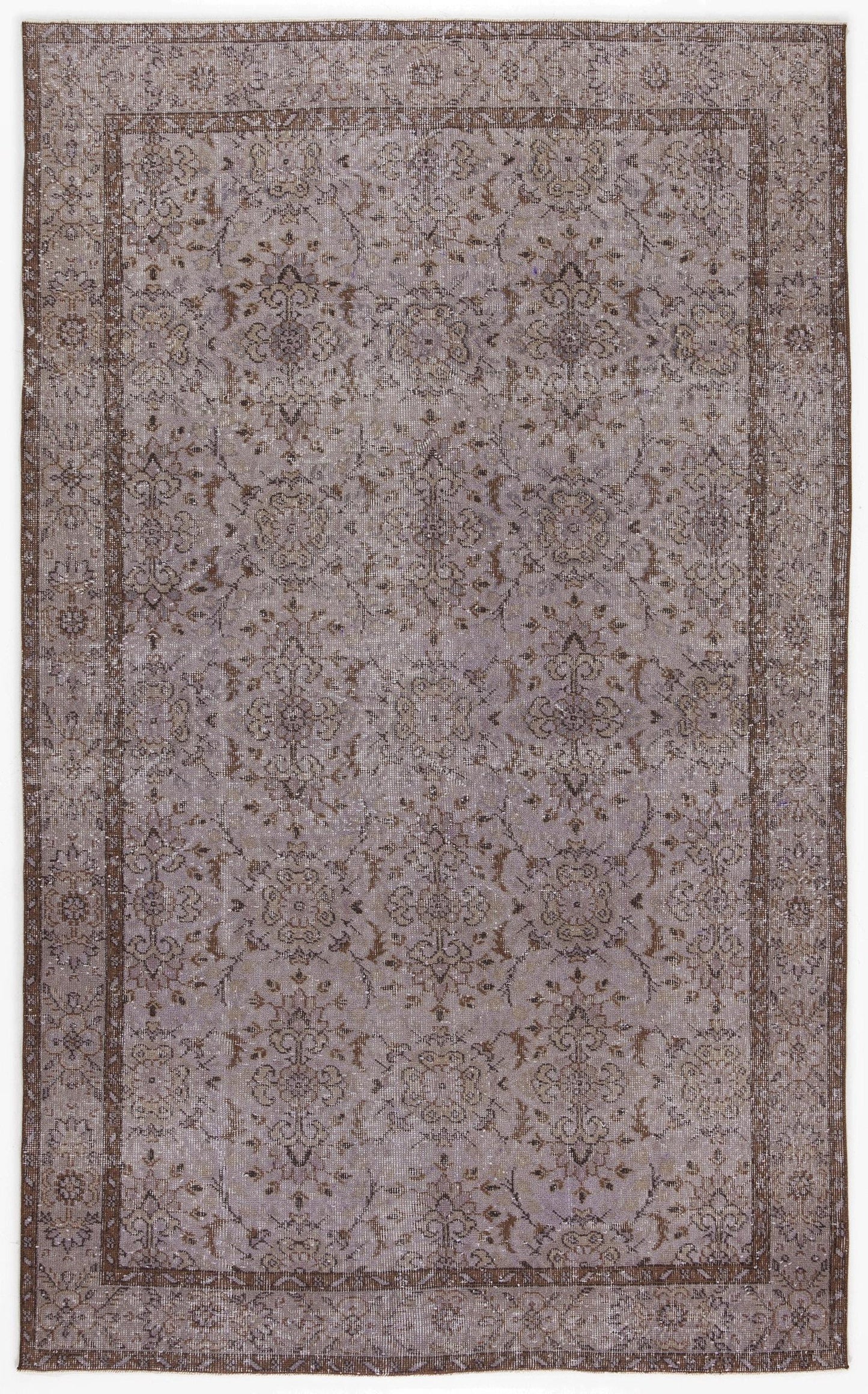 Distressed lavender and brown rug with a traditional floral medallion pattern and a wide decorative border.