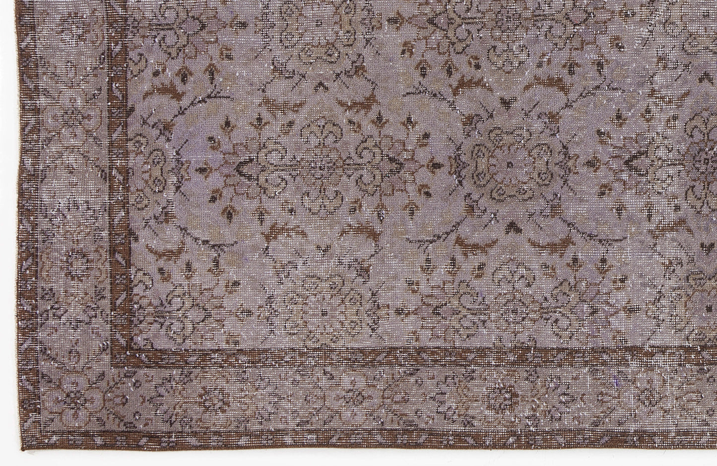 Lavender and brown distressed rug with a traditional floral medallion pattern and a decorative border.