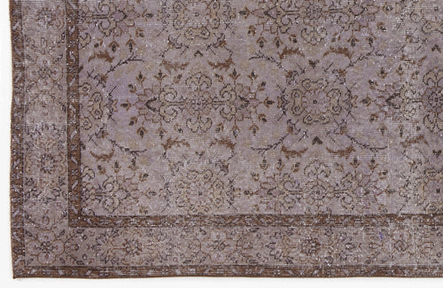 Load image 1 in gallery view. Lavender and brown distressed rug with a traditional floral medallion pattern and a decorative border.