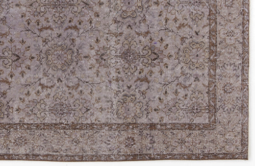 Load image 1 in gallery view. Distressed lavender and brown rug with a traditional floral medallion pattern and a wide decorative border.