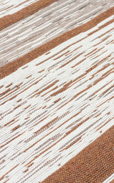 A close-up of Calm Thread - Washable Double-Sided Kilims - AR27 shows alternating brown and white stripes. Loosely woven, uneven white threads evoke a rustic cream kilim rug, enhancing the textured look.