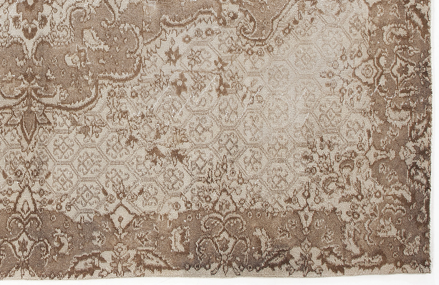 Taupe and beige rug with a distressed, traditional floral medallion pattern and faded geometric details.