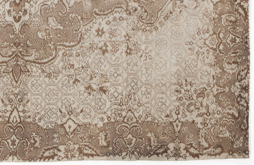 Load image 1 in gallery view. Taupe and beige rug with a distressed, traditional floral medallion pattern and faded geometric details.