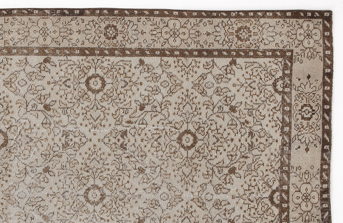 Beige and brown rug with a distressed traditional floral medallion pattern and a decorative border.