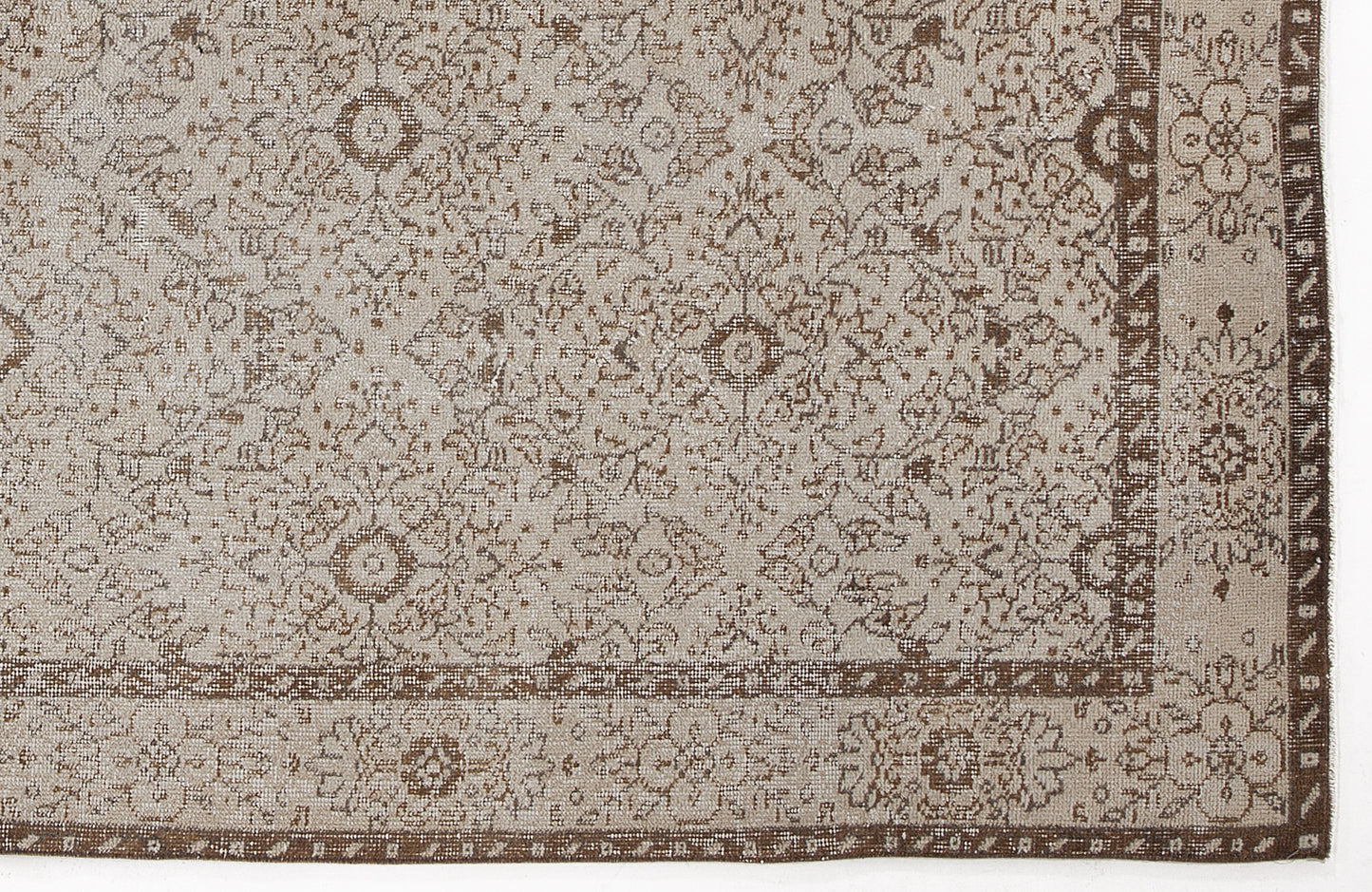 Beige and brown rug with a distressed traditional floral medallion pattern and a decorative border.